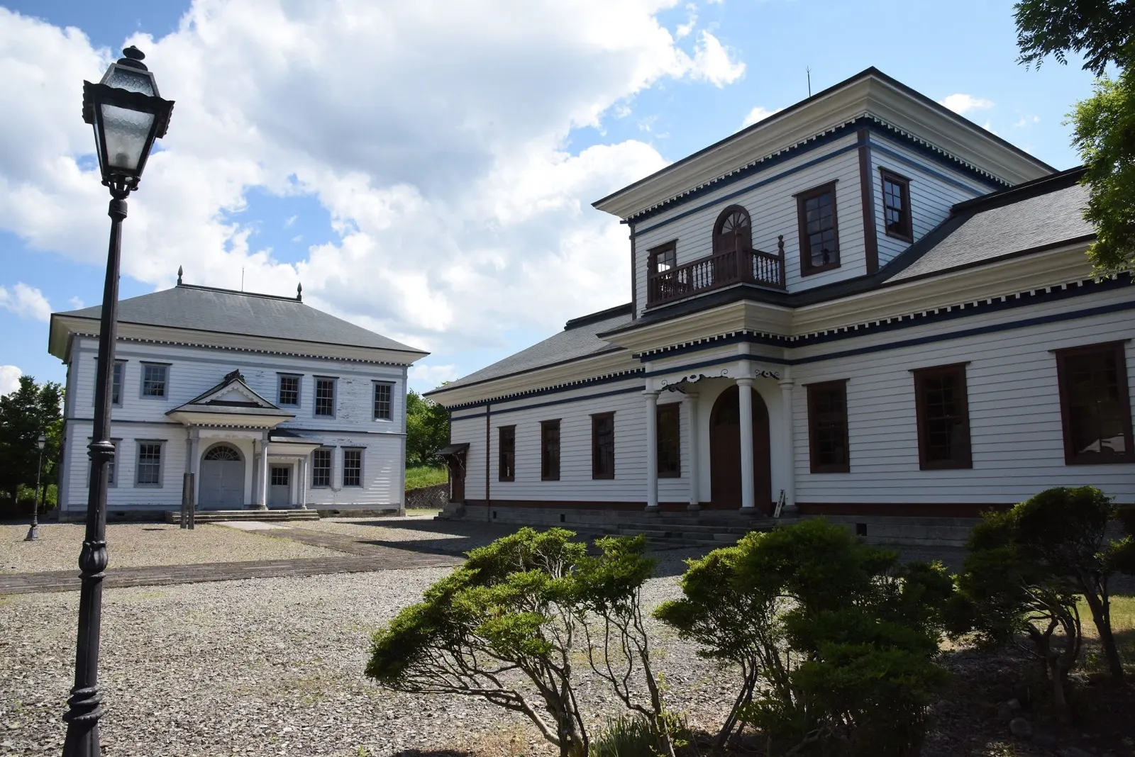 白い外壁の建物と中庭が見える寒河江市郷土館